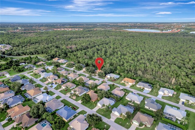 drone / aerial view featuring a water view, a residential view, and a wooded view