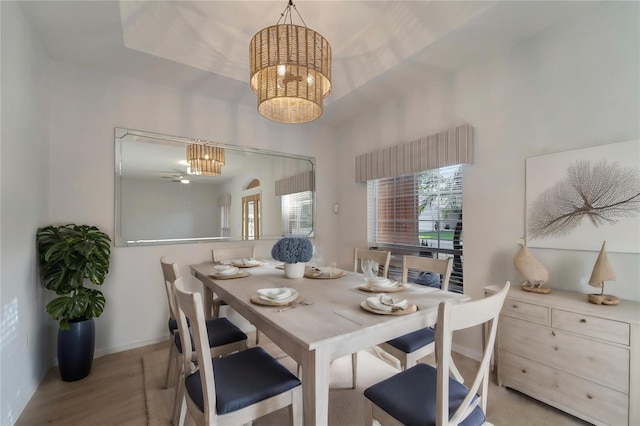 dining space featuring light wood-type flooring, baseboards, and an inviting chandelier