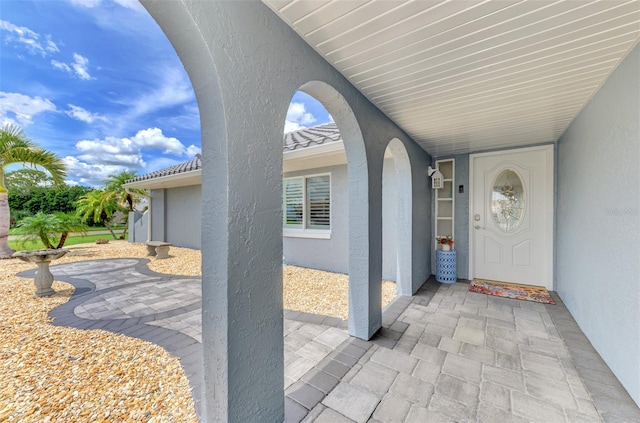 view of exterior entry with a patio area