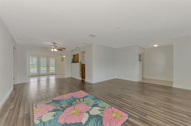 unfurnished living room featuring wood-type flooring and ceiling fan