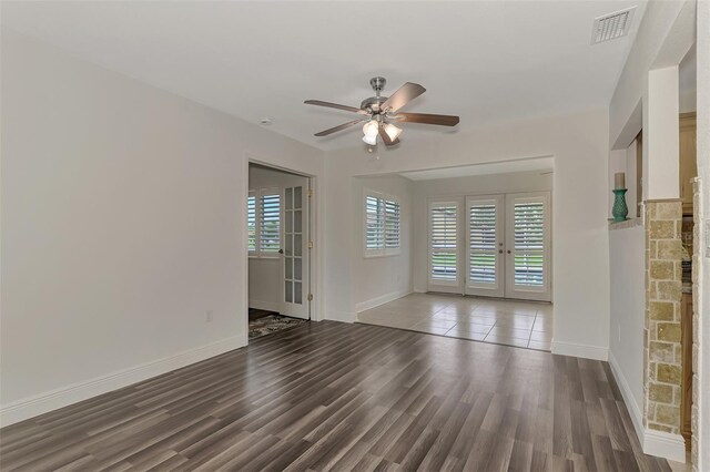 empty room with ceiling fan, dark hardwood / wood-style flooring, and french doors