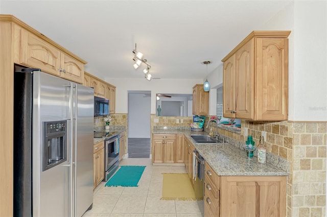 kitchen with appliances with stainless steel finishes, light stone countertops, sink, pendant lighting, and tasteful backsplash