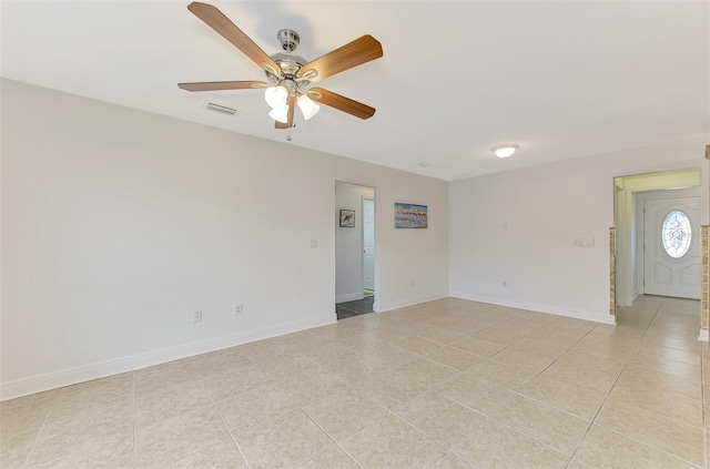 tiled spare room featuring ceiling fan