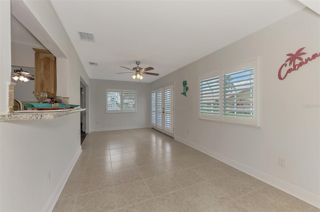 interior space with light tile patterned floors and ceiling fan