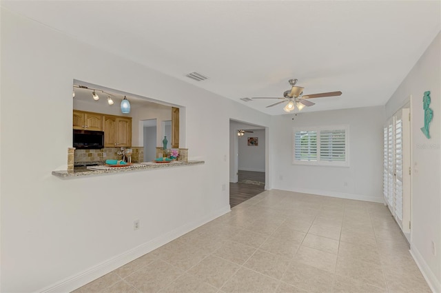 empty room with ceiling fan and light tile patterned flooring