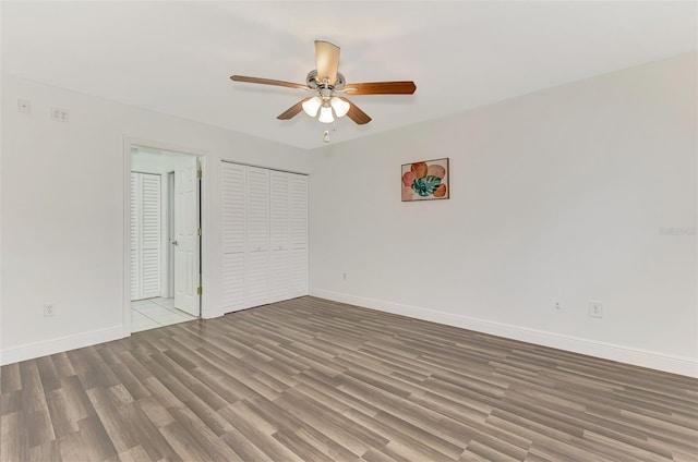 unfurnished bedroom with a closet, ceiling fan, and hardwood / wood-style flooring