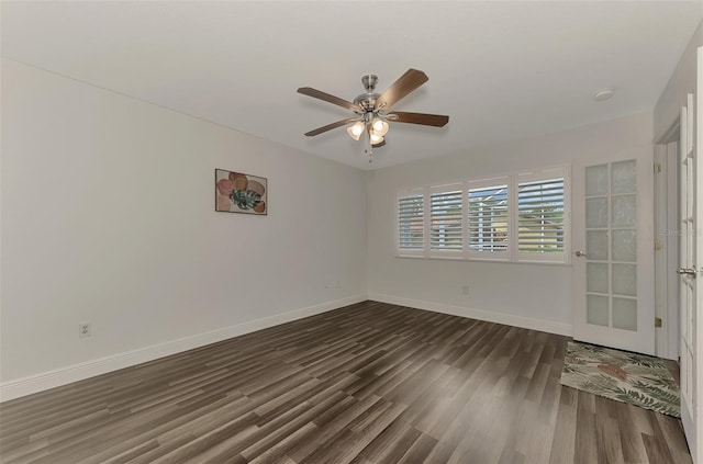 spare room featuring dark wood-type flooring and ceiling fan