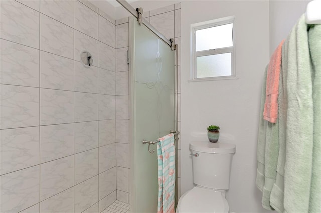 bathroom featuring toilet and a tile shower