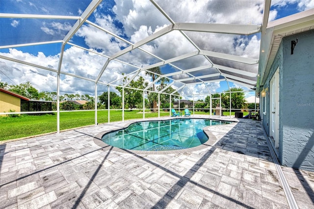 view of swimming pool featuring glass enclosure, a patio area, and a lawn