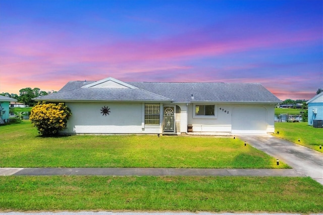 ranch-style home with cooling unit and a lawn