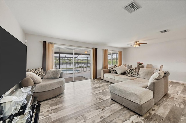 living room featuring light wood-type flooring and ceiling fan