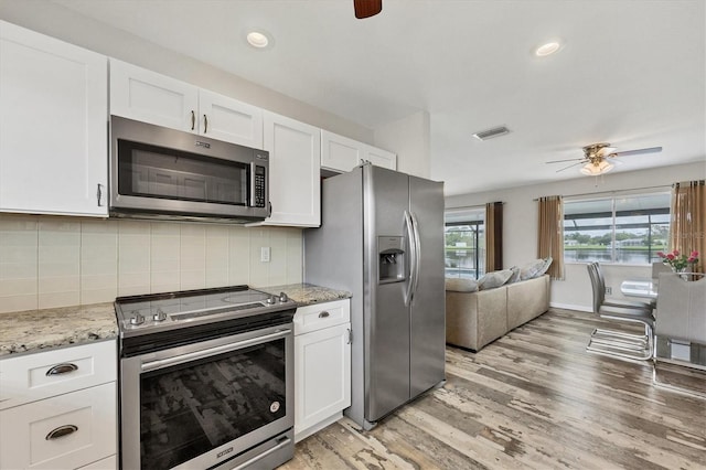 kitchen with light hardwood / wood-style flooring, tasteful backsplash, stainless steel appliances, white cabinetry, and ceiling fan