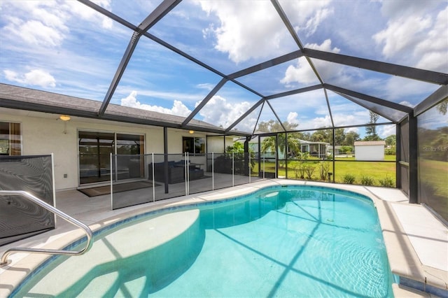 view of pool with glass enclosure, a patio area, and a lawn