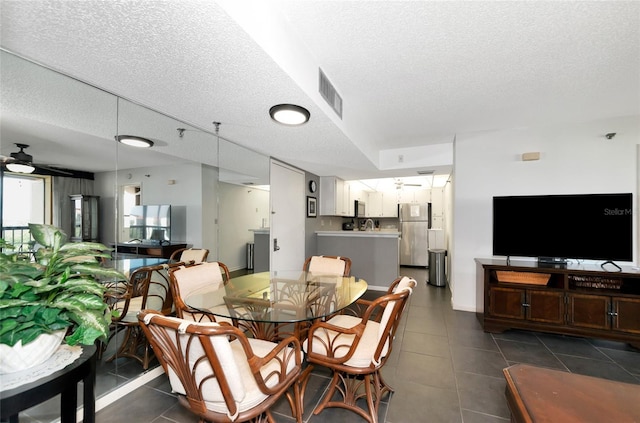 dining space featuring ceiling fan and a textured ceiling