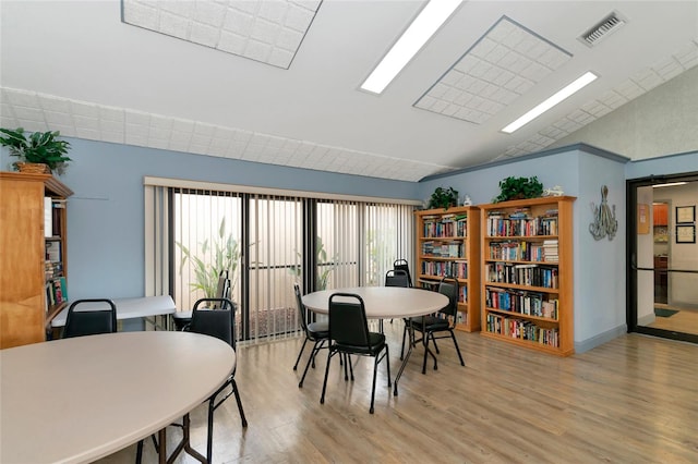 dining space with light wood-type flooring and lofted ceiling