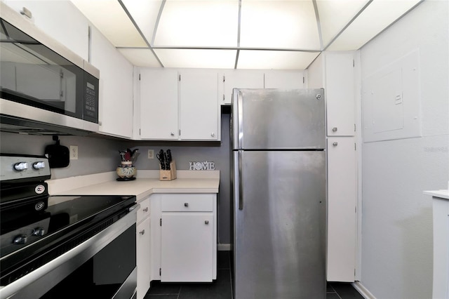 kitchen featuring white cabinetry, electric panel, appliances with stainless steel finishes, and dark tile patterned flooring