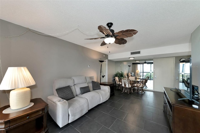 living room with a textured ceiling and ceiling fan