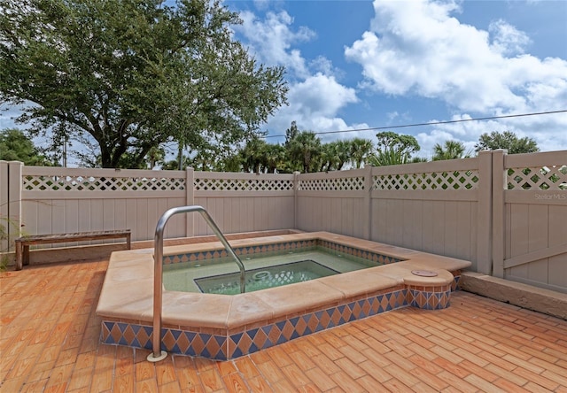 view of swimming pool featuring an in ground hot tub and a patio area