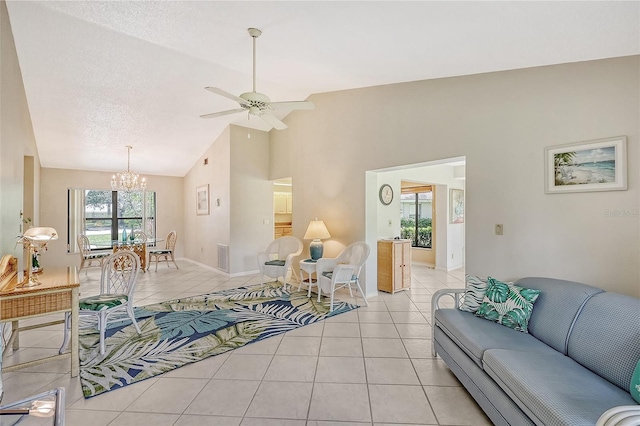 living area with baseboards, ceiling fan with notable chandelier, a textured ceiling, and light tile patterned flooring