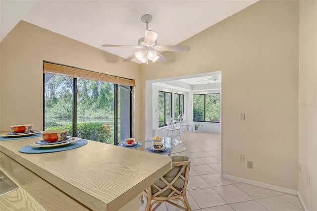 dining space featuring a ceiling fan, baseboards, and light tile patterned floors