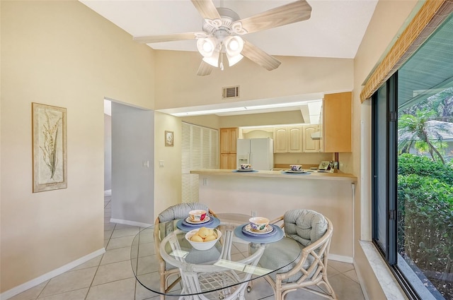 dining space with vaulted ceiling, light tile patterned floors, and ceiling fan