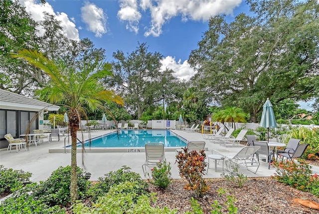 community pool with a patio and fence