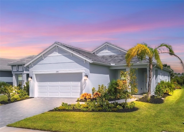 single story home featuring a lawn and a garage