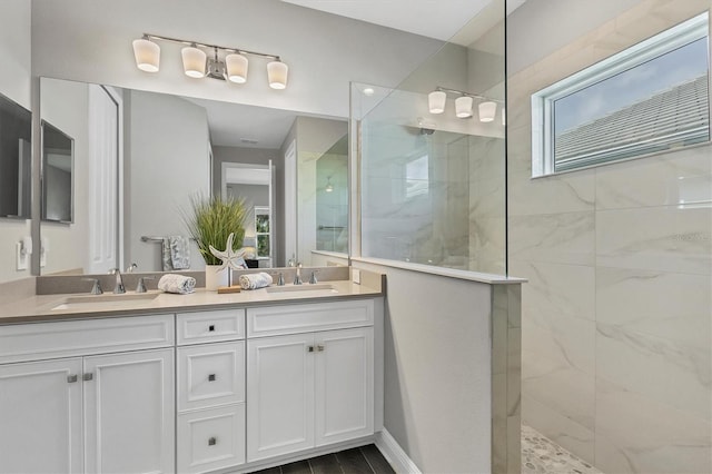 bathroom featuring tiled shower, hardwood / wood-style floors, a wealth of natural light, and vanity