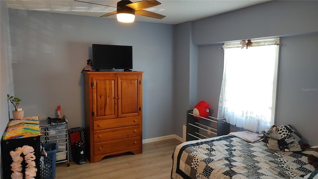 bedroom featuring multiple windows, hardwood / wood-style floors, and ceiling fan