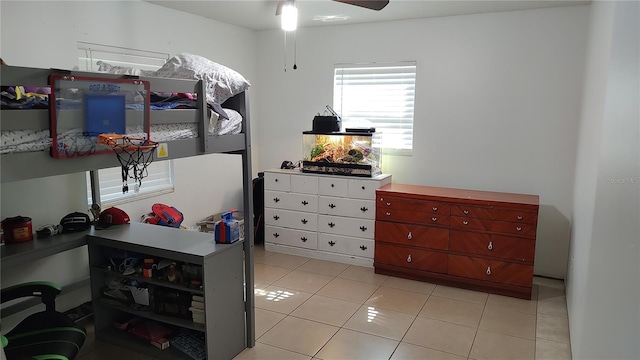 tiled bedroom featuring ceiling fan