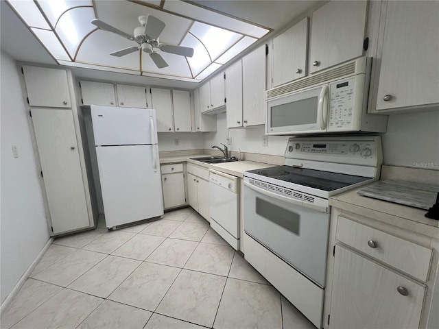 kitchen with white appliances, a skylight, light tile patterned floors, sink, and ceiling fan