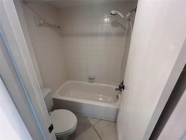 bathroom with tile patterned flooring, toilet, and tiled shower / bath combo