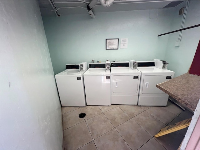 clothes washing area featuring light tile patterned floors and washer and dryer