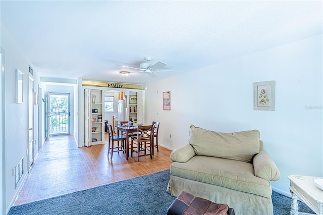 living room with wood-type flooring and ceiling fan