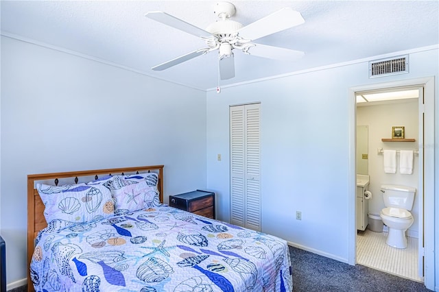 carpeted bedroom with ceiling fan, a closet, and ensuite bath