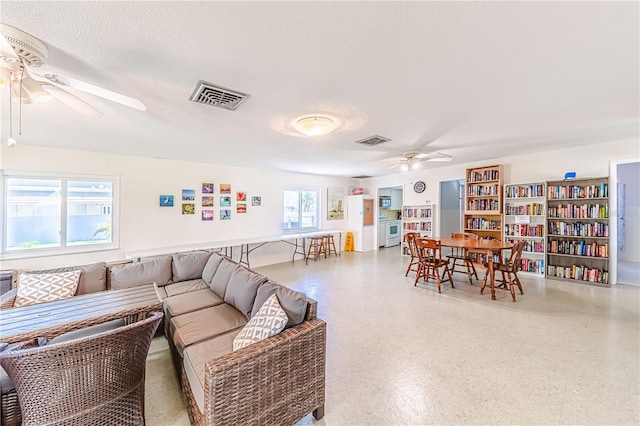 living room featuring a textured ceiling and ceiling fan