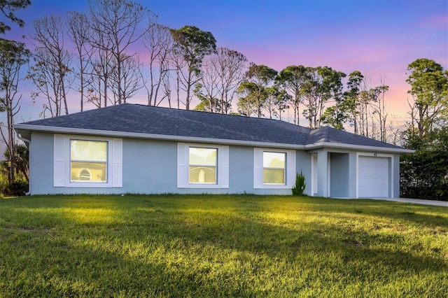 ranch-style home with a yard and a garage