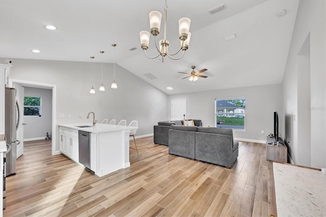 kitchen featuring pendant lighting, ceiling fan with notable chandelier, white cabinetry, and light hardwood / wood-style floors