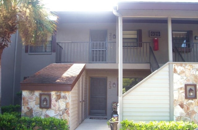 view of exterior entry featuring a balcony