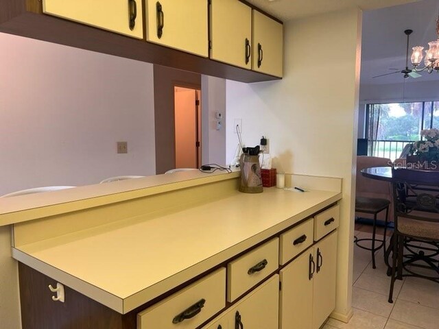 kitchen with light tile patterned floors, an inviting chandelier, and sink