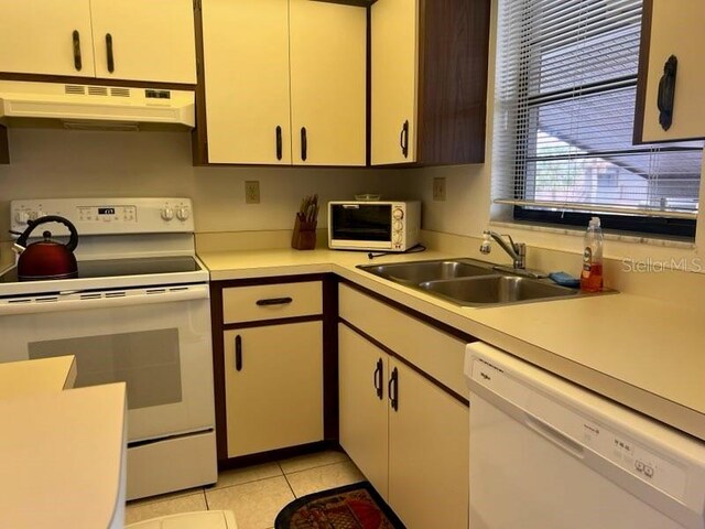 kitchen with sink, light tile patterned floors, and white appliances