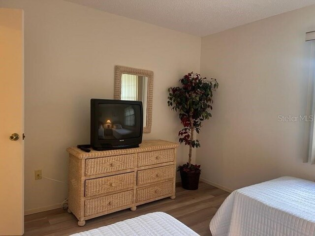 bedroom featuring a textured ceiling and hardwood / wood-style flooring