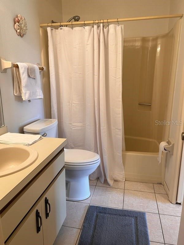 full bathroom with vanity, toilet, shower / tub combo, and tile patterned floors