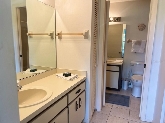 bathroom featuring vanity, toilet, and tile patterned floors