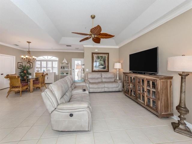 living room with ceiling fan with notable chandelier, a raised ceiling, ornamental molding, and light tile patterned flooring