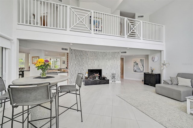 living room featuring a towering ceiling and light tile patterned floors