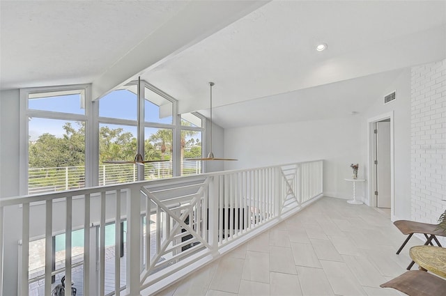 hall featuring light tile patterned floors and vaulted ceiling with beams