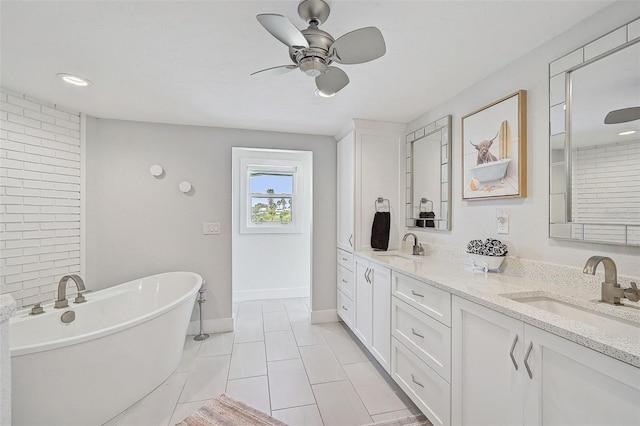 bathroom featuring tile patterned flooring, vanity, ceiling fan, and a washtub