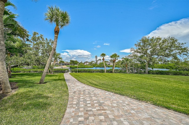 view of home's community with a lawn and a water view