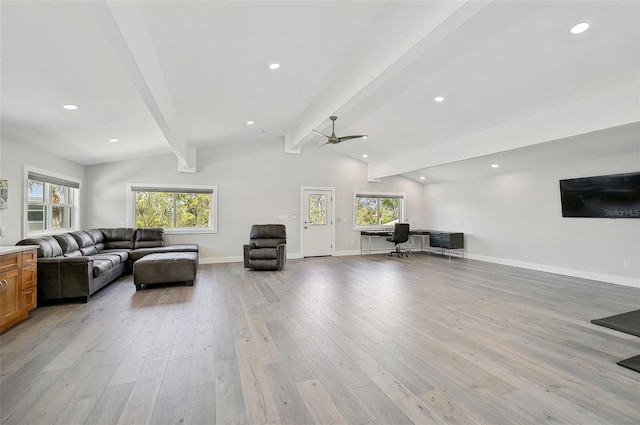 living room with a healthy amount of sunlight, ceiling fan, light hardwood / wood-style flooring, and vaulted ceiling with beams